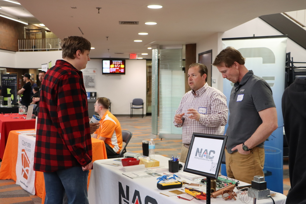 A student talking to industry professionals. 