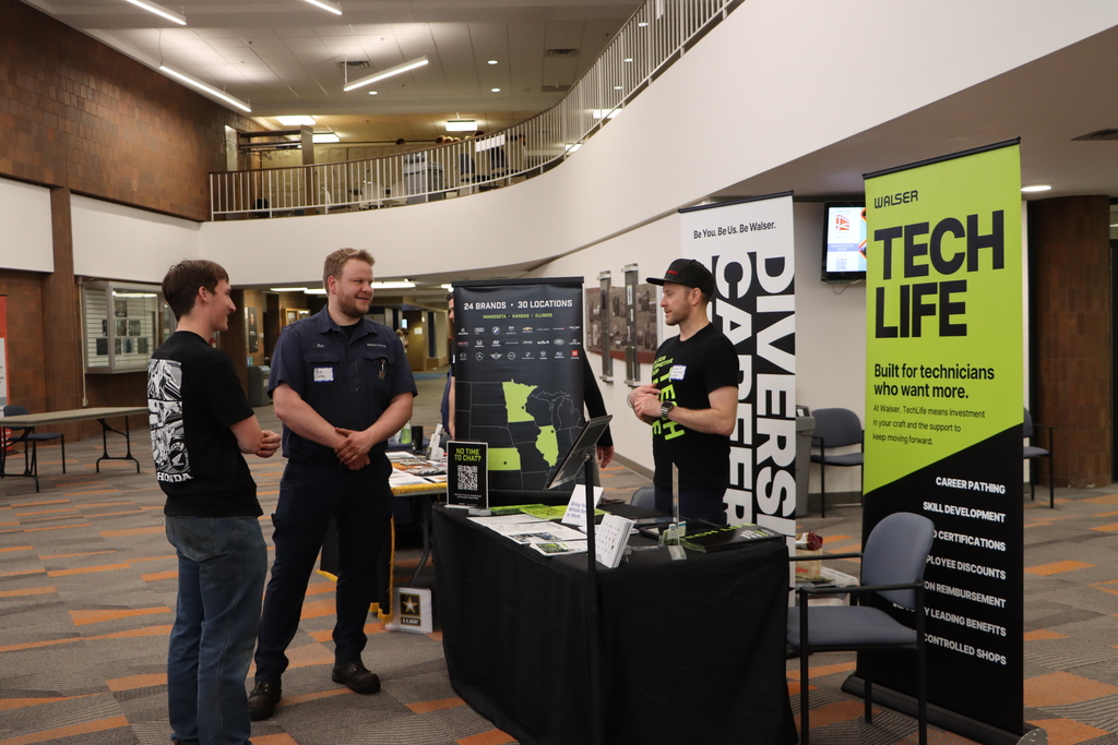 A student talking to industry professionals. 
