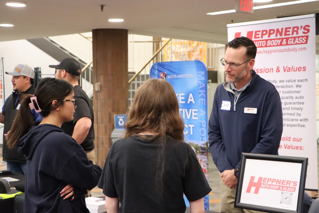 Two students talking to an industry professional. 