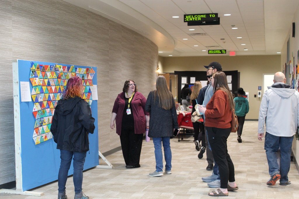 A group of people standing around and talking with each other.