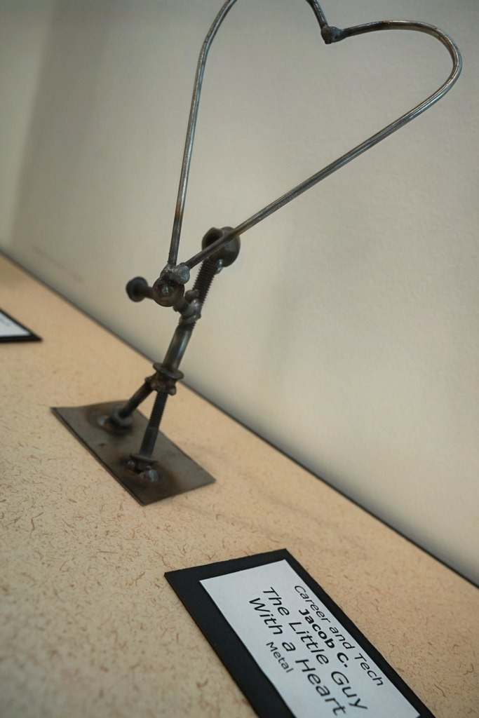 Metal art worked into a person holding a heart.