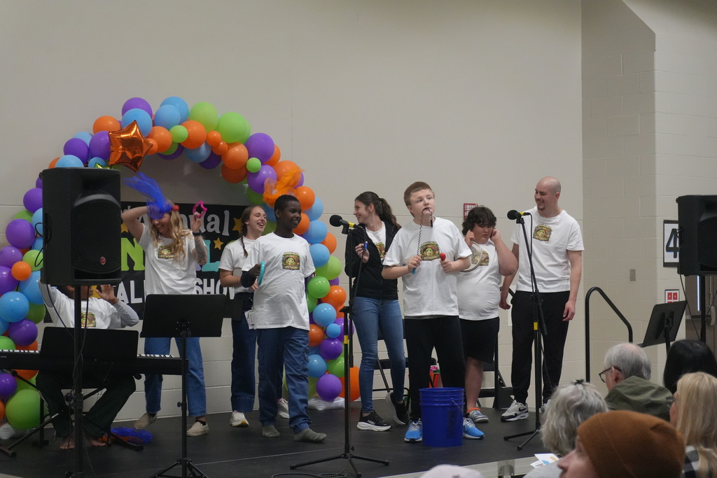 A group of students and staff performing on stage for the talent show.