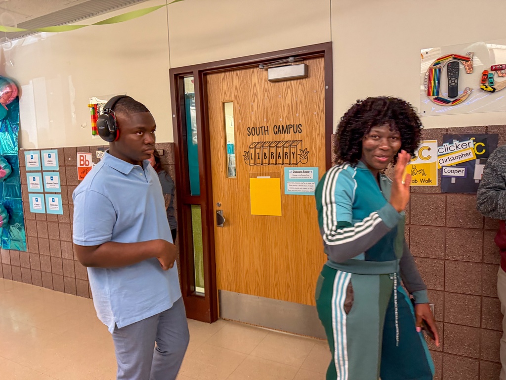 Parent waving as they do the grand march with student.