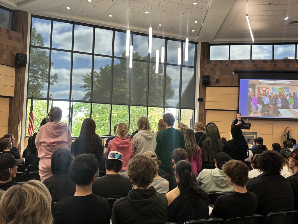 Students and staff at a end of year assembly and celebrating.
