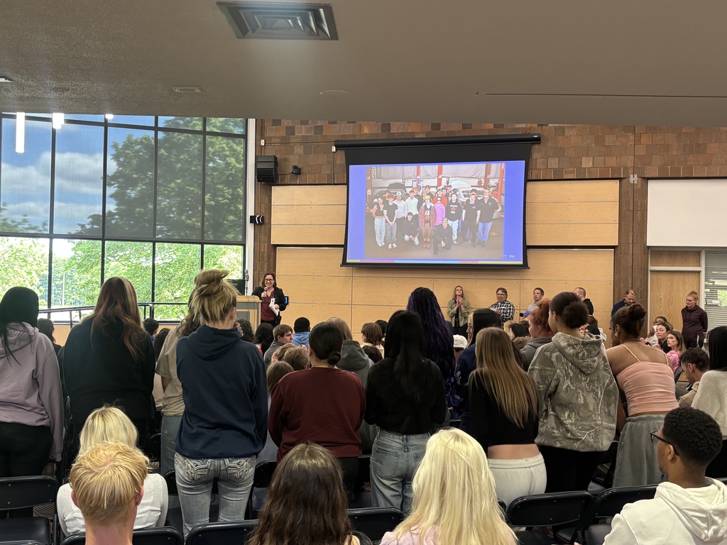 Students and staff at a end of year assembly and celebrating.