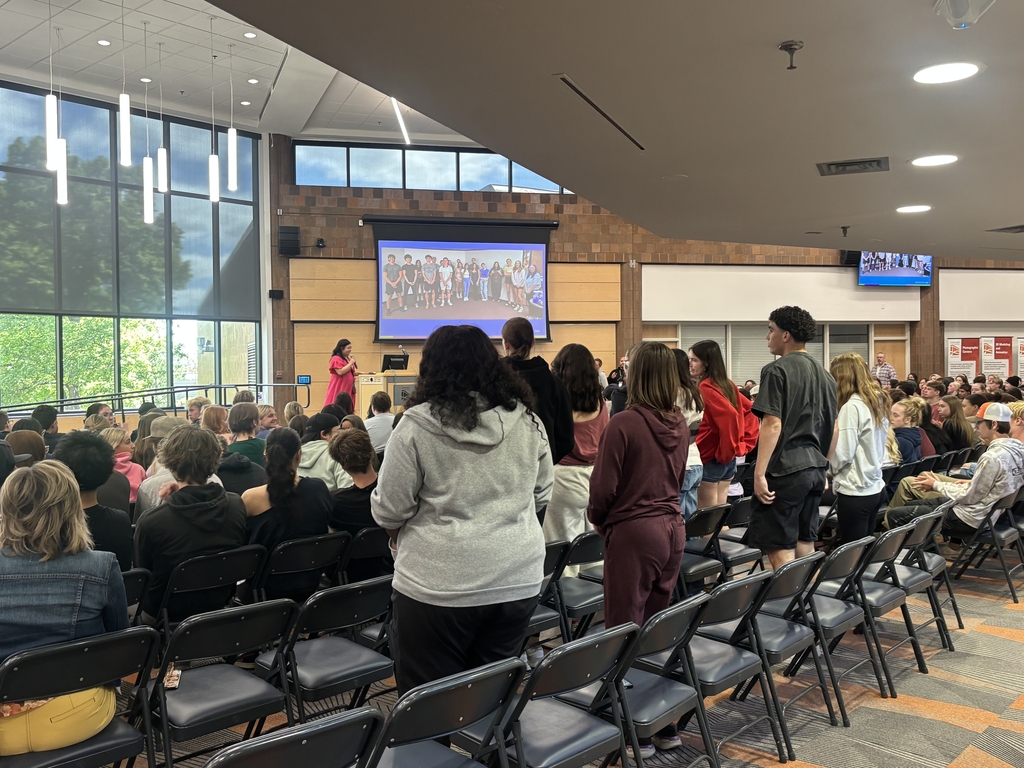 Students and staff at a end of year assembly and celebrating.