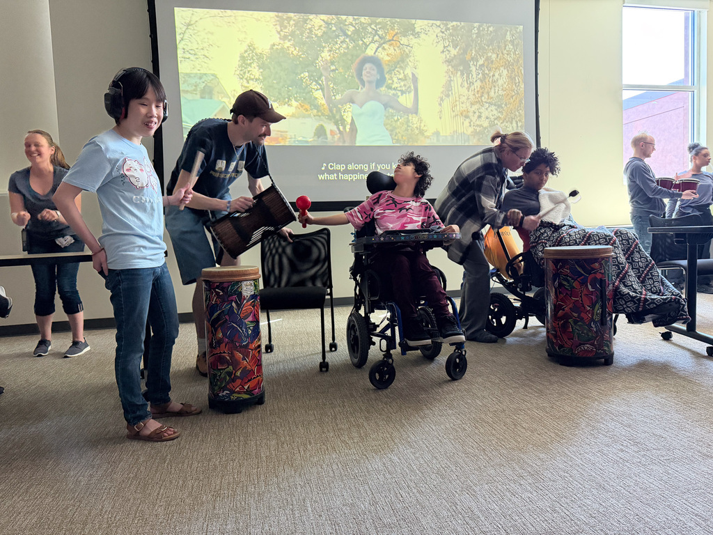 A group of students playing the drums to a song.