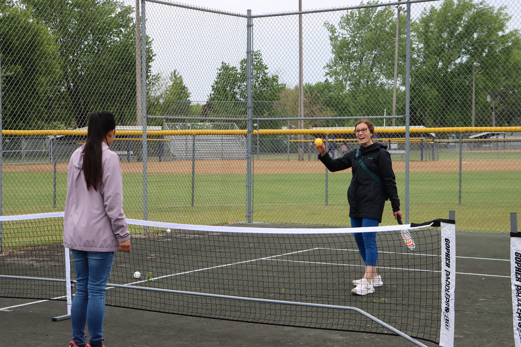 Staff about to throw a pickleball at a student for them to hit with the rack. 