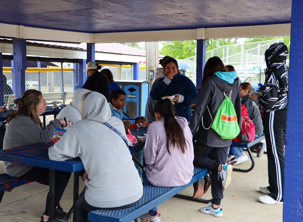 Staff and students sitting down eating lunch. 