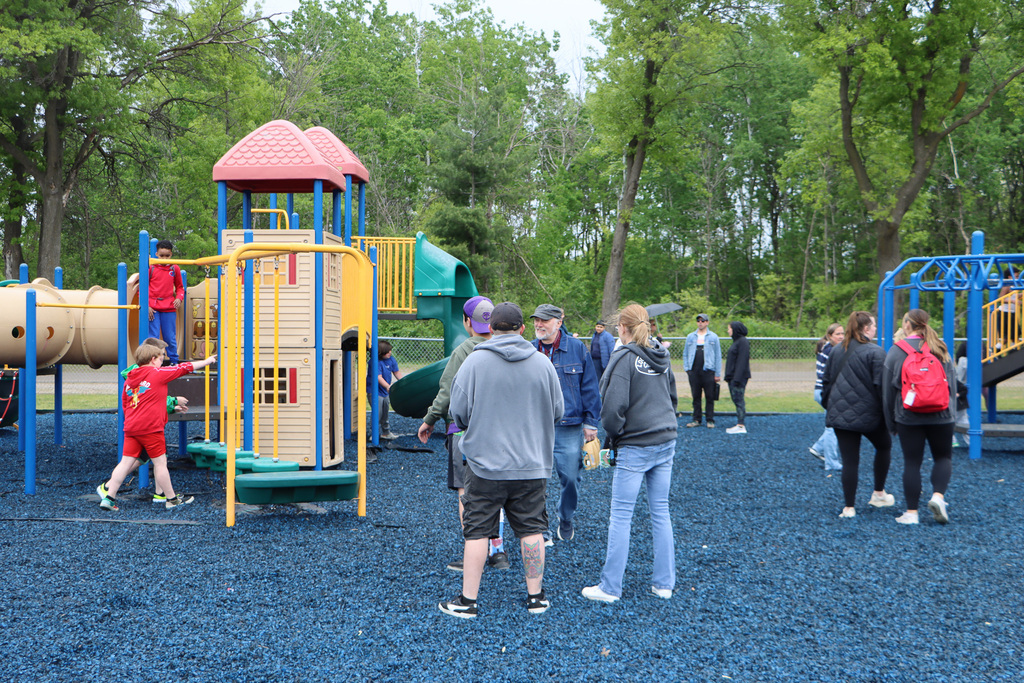 Students playing on the playground while staff supervise. 