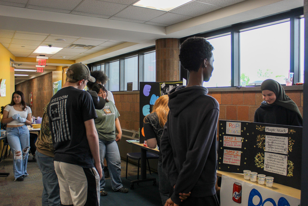 Students talking to other students at their informational booth at the health fair. 