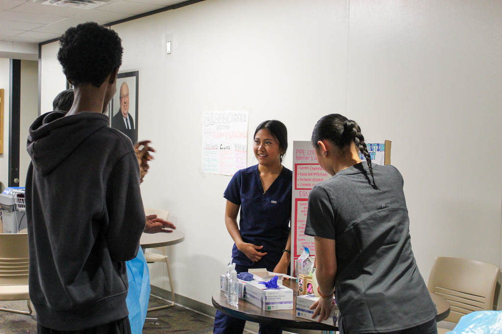 Students teaching how to properly put on medical clothing. 
