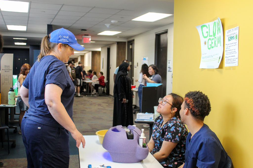 Staff talking to students at their informational booth.