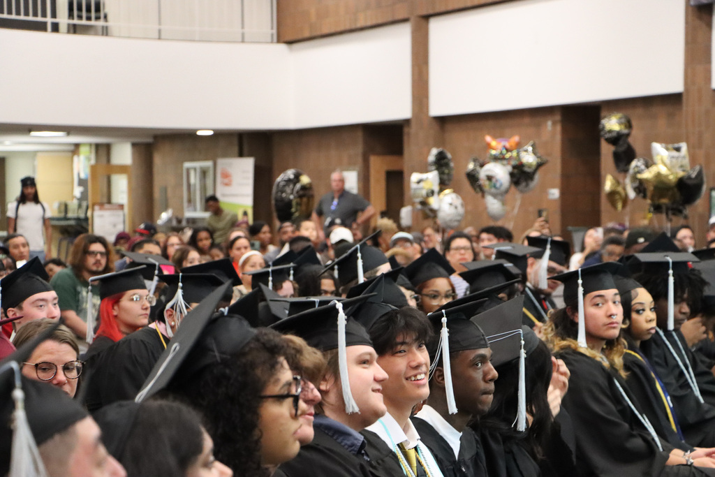 Student graduates, staff, and families attending a graduation.