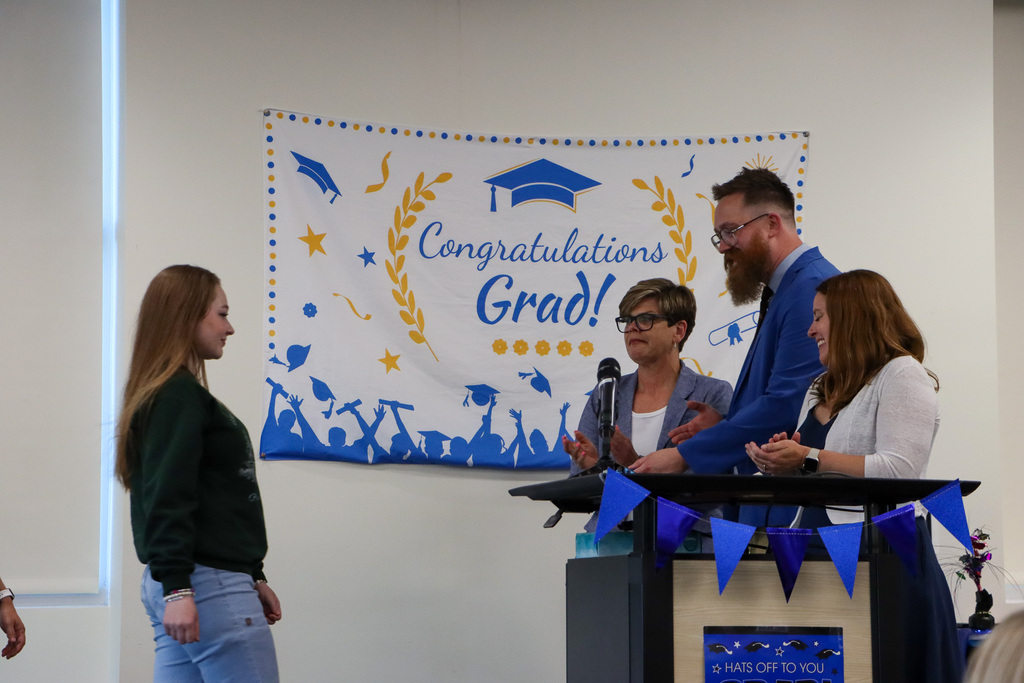 Student graduate walking up to staff during graduation.