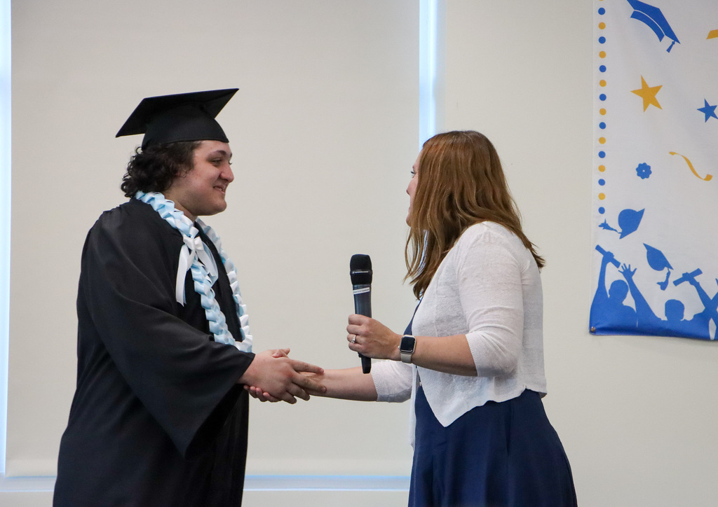 Graduate and principal shaking hands. 