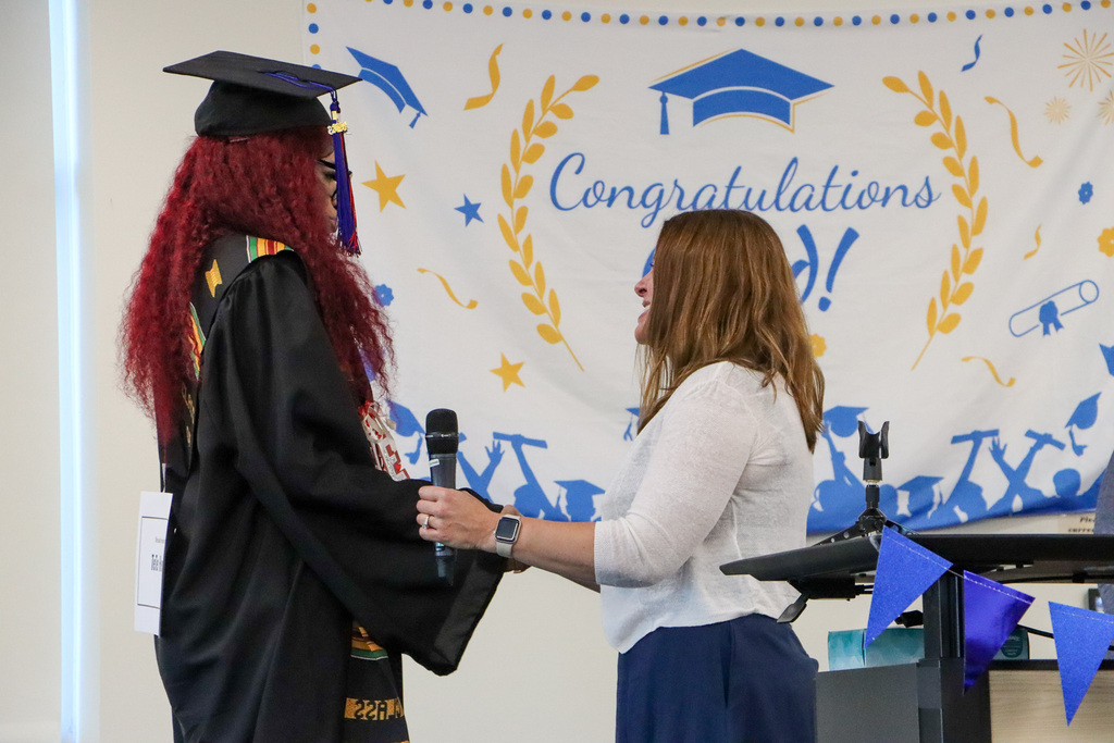 Graduate and principal shaking hands. 