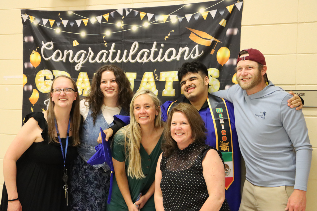 Staff with student graduate and smiling for a picture. 