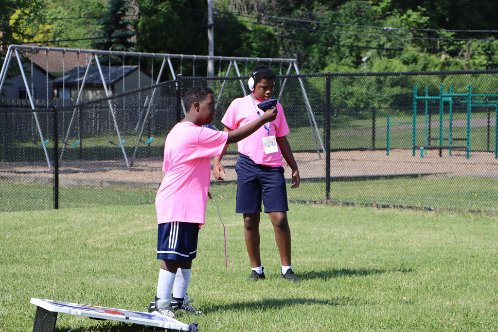 Student getting ready to toss a bean bag into the corn hole. 