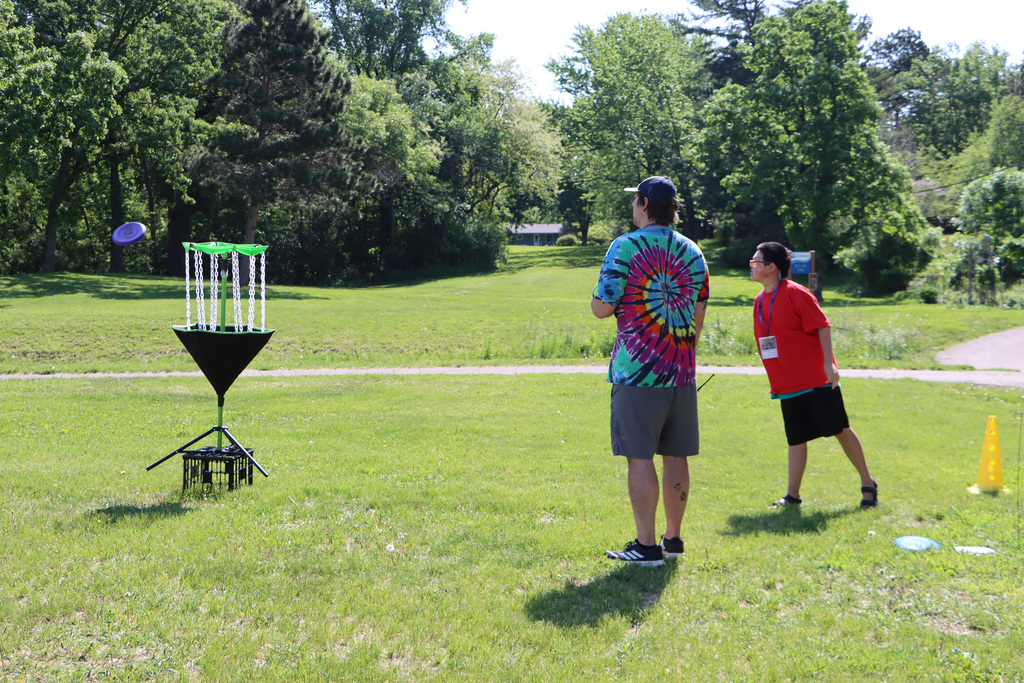 A student throwing a frisbee for disc golf. 