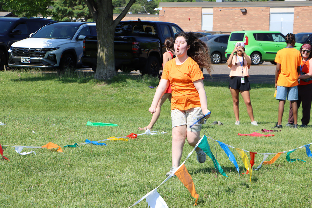 Student running down a pathway with flags. 