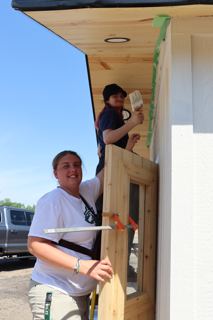 Two students painting the student built sauna. 