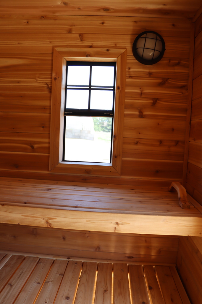 The inside of the student built sauna made with wood and the window in the middle of the frame. 