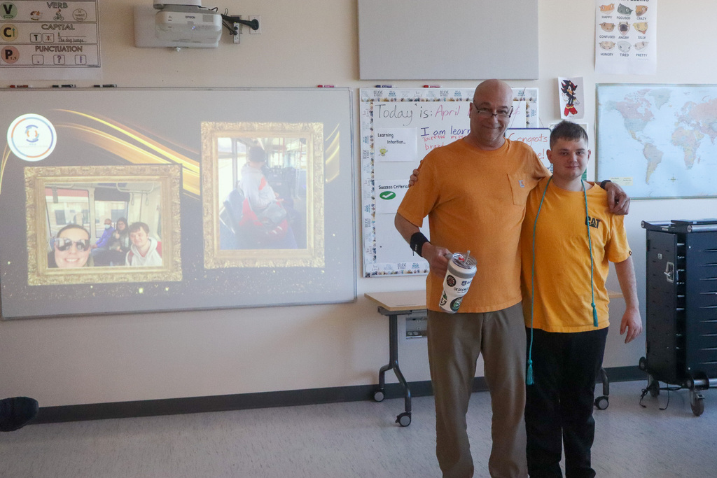 Staff and student taking a picture together in celebration of the student graduating. 