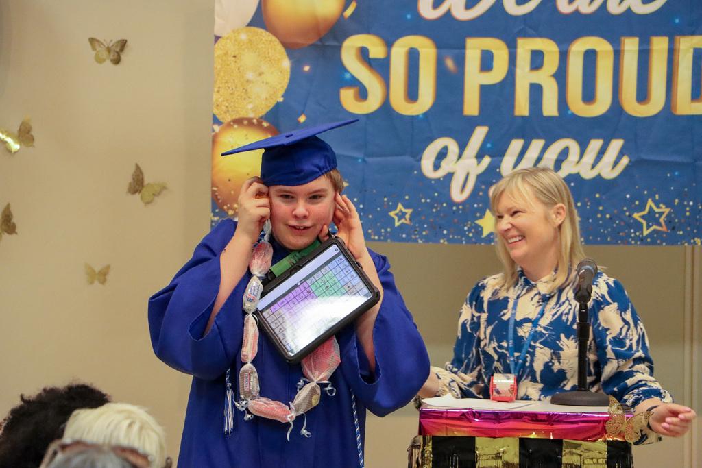 Principal handing student a certificate during graduation ceremony.