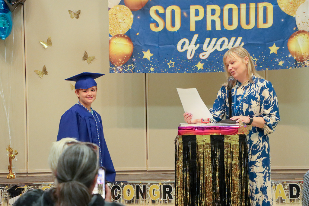 Principal handing student a certificate during graduation ceremony.
