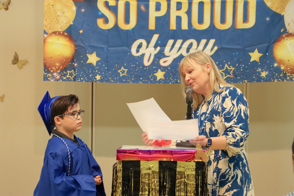 Principal handing student a certificate during graduation ceremony.
