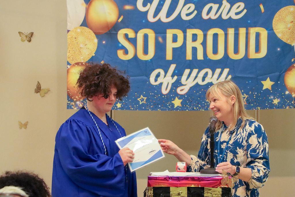 Principal handing student a certificate during graduation ceremony.