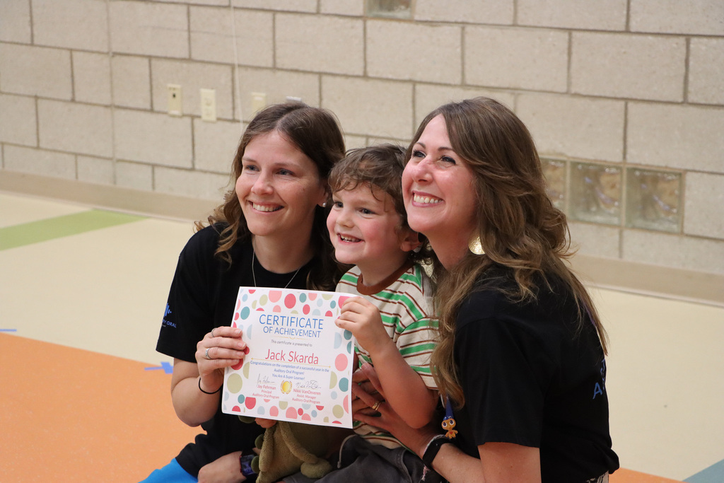 Student and staff holding a certificate of achievement.