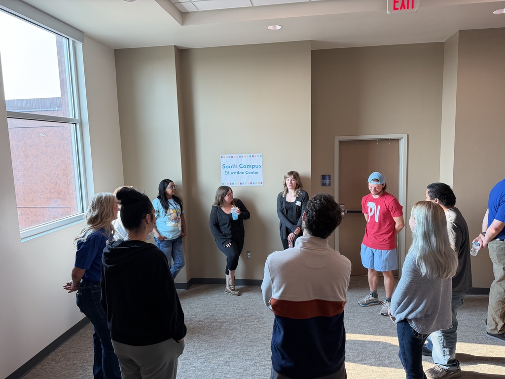 Staff gathered in a circle and talking with each other.