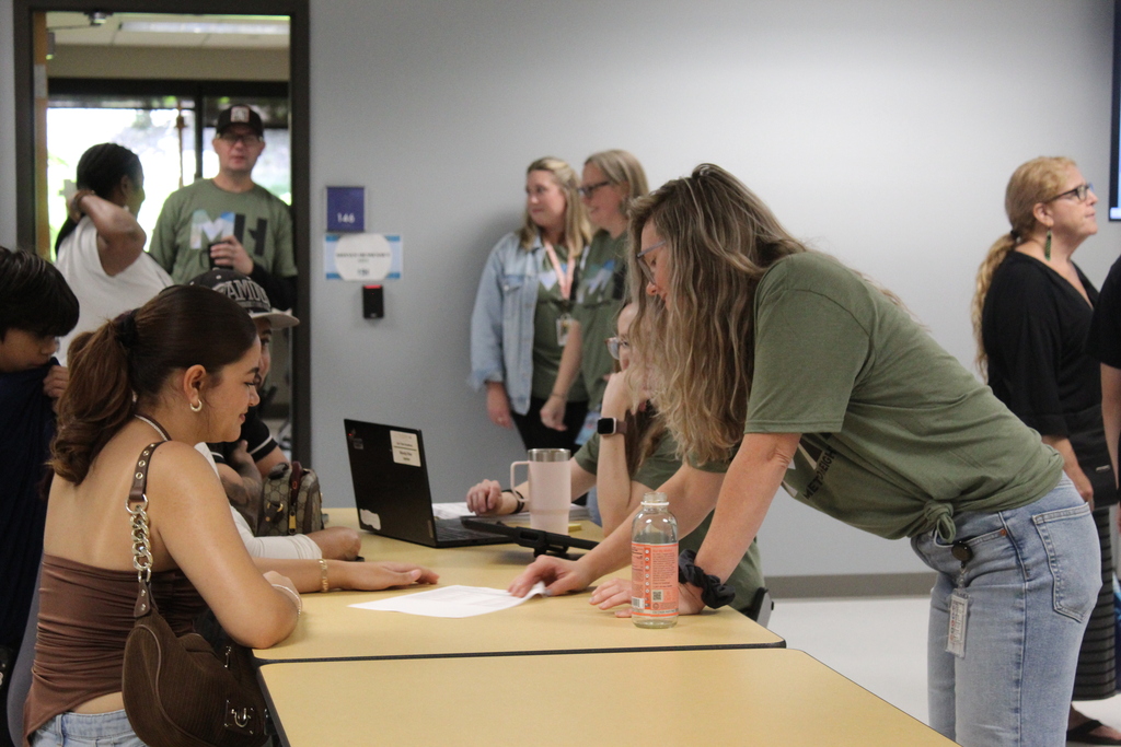 Staff showing a student a document during open house.