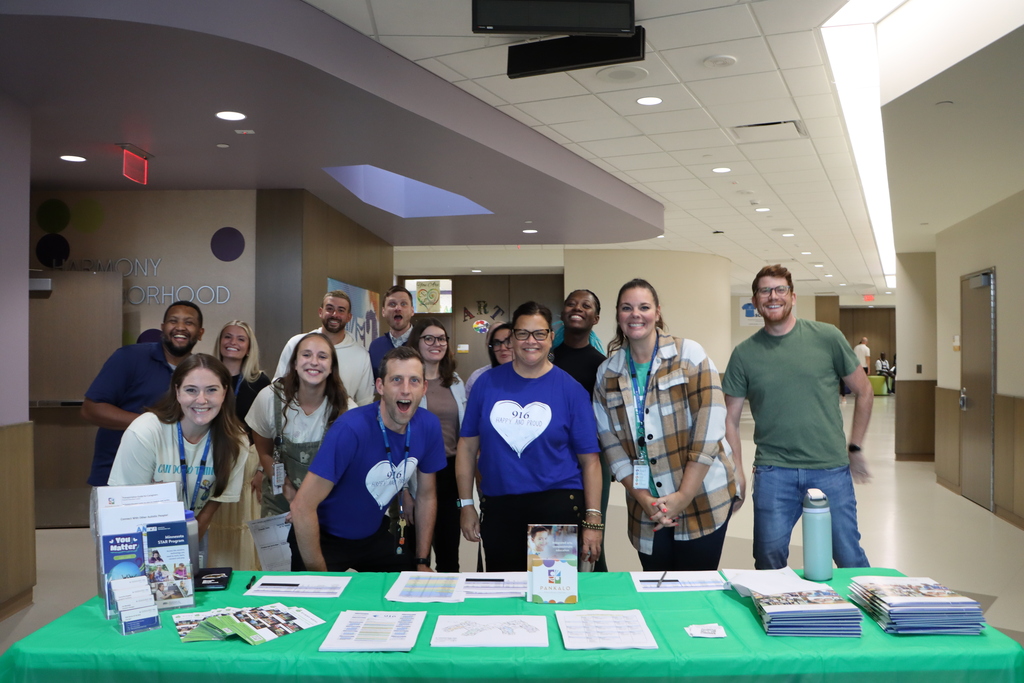 Staff smiling happily for a picture during open house. 