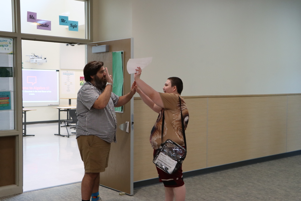 Student and staff giving each other a high five.
