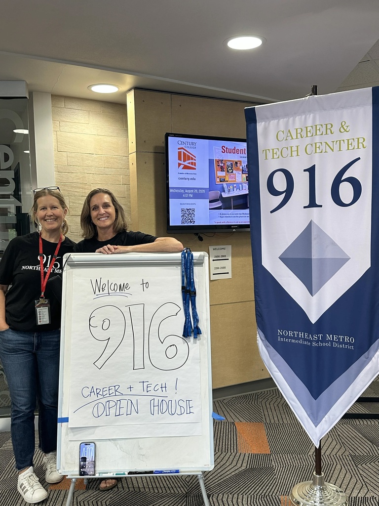 Staff smiling with the 916 Career and Tech Center signs in front of them. 