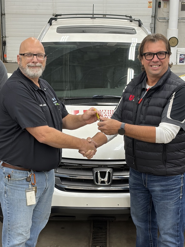 Community member handing off key to the Auto Tech teacher.