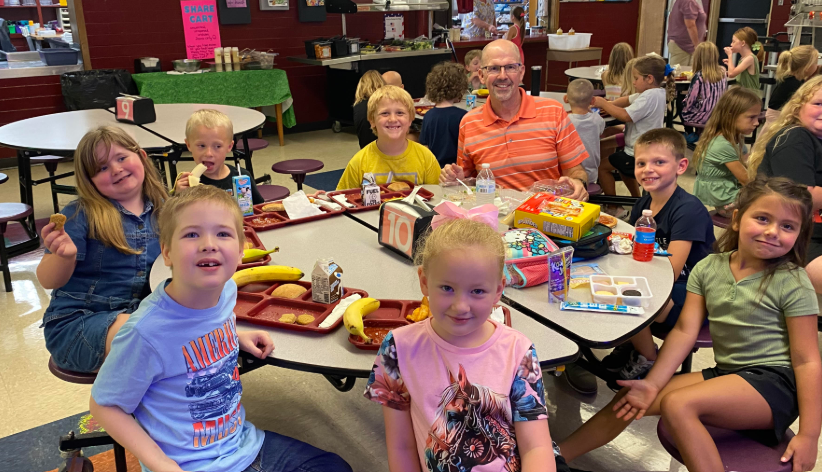 Mr. Streeter eating lunch with 1st graders