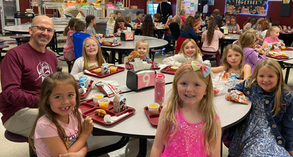 Dr Streeter eating lunch with 1st grade students