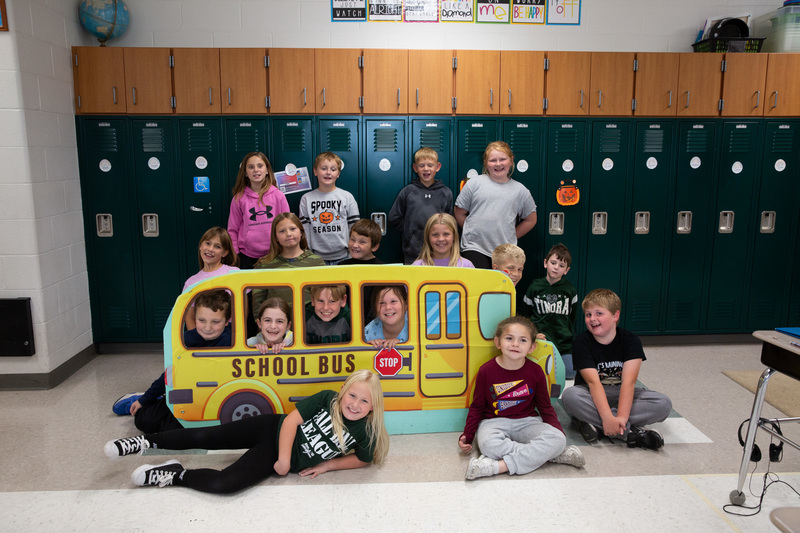 class posing with the bus