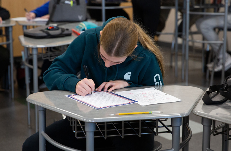 child at desk writing a letter