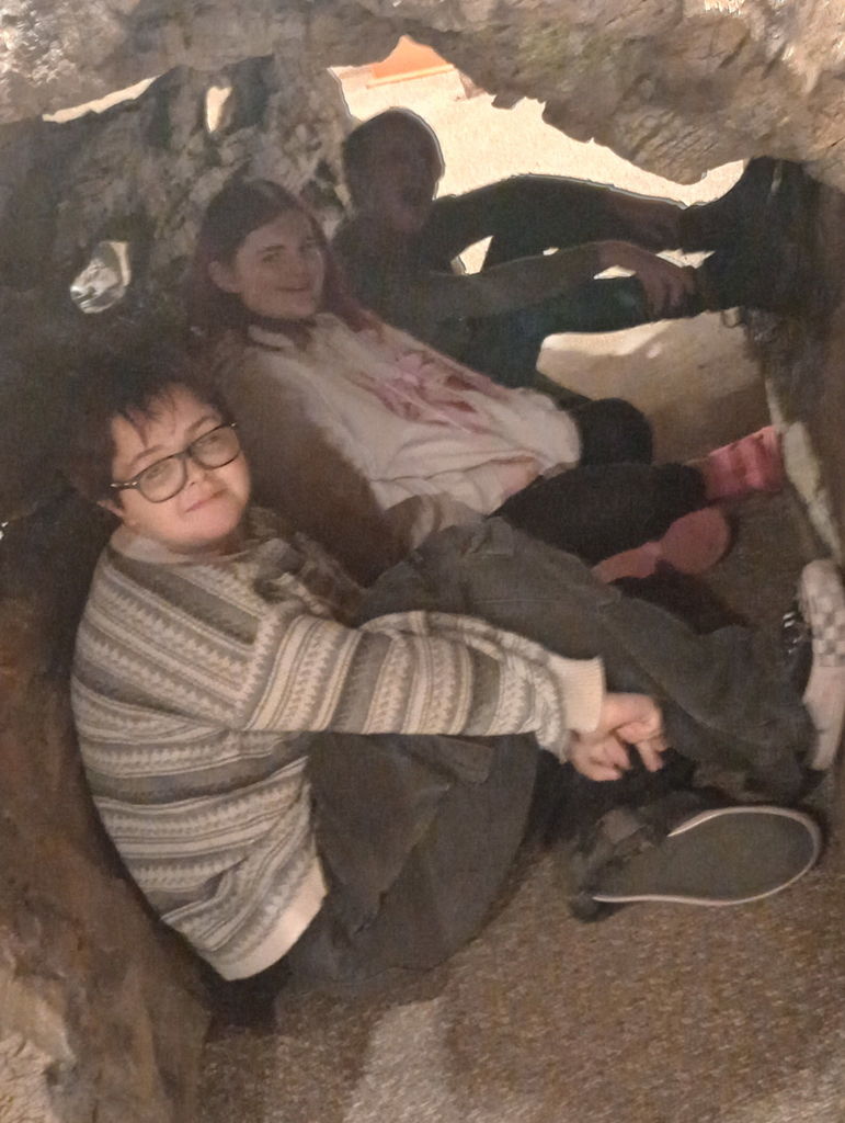 Forest History Center - 3 students sitting inside  the hollow of a giant log