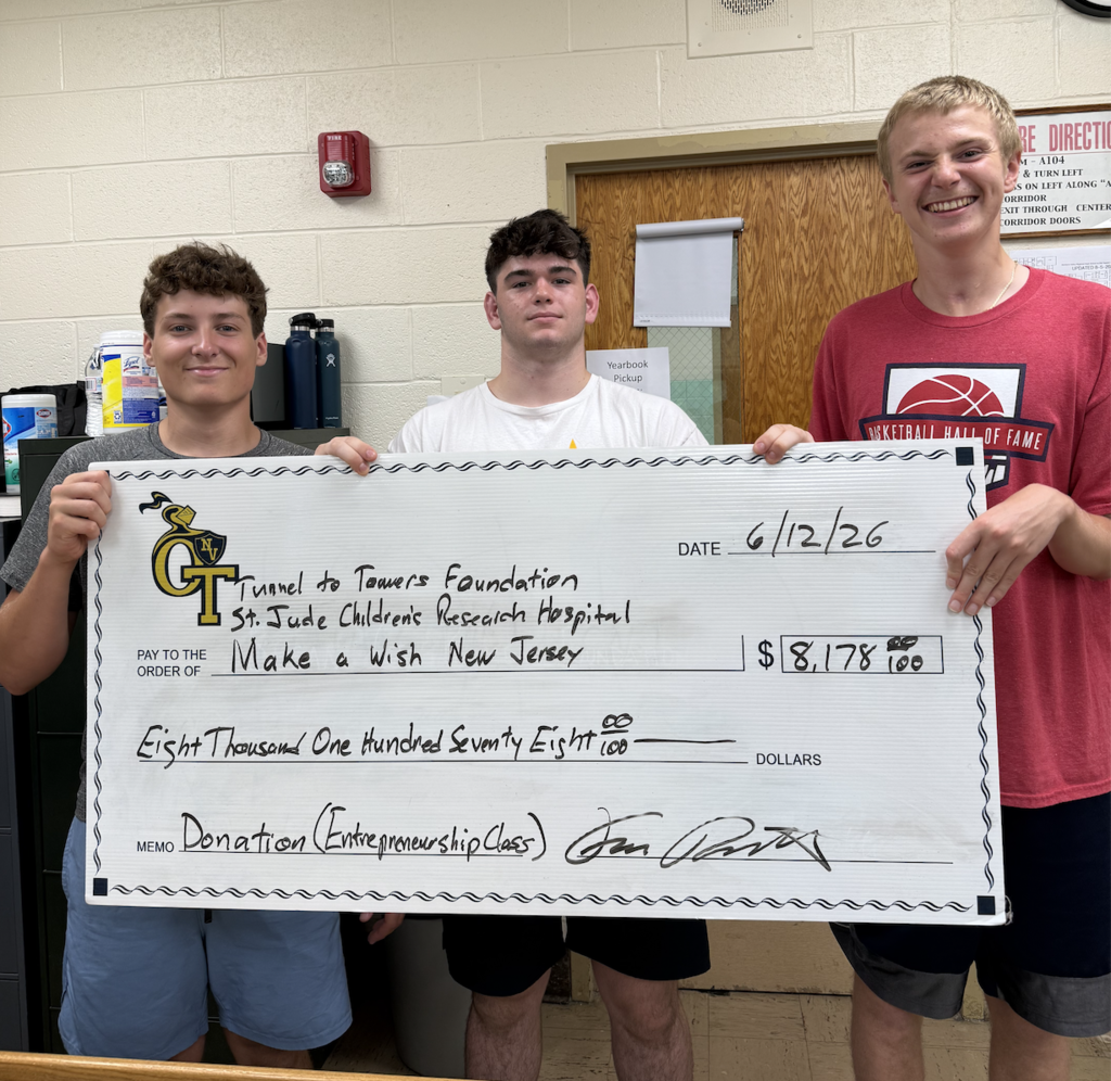 Three young men present a check for $8,178.86 to a foundation. The check is white with bold text and numbers.