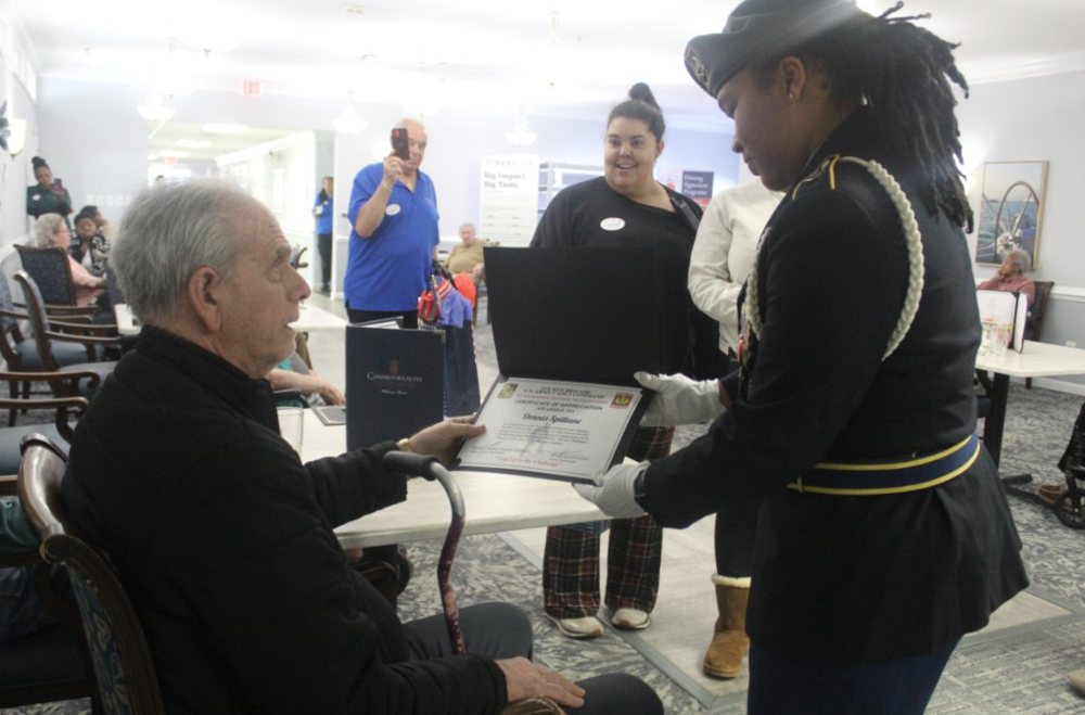 Army JROTC Cadet Kiera Coleman presents a certificate of appreciation to a veteran. (Photo by Cadet Keymah J. Clarke)