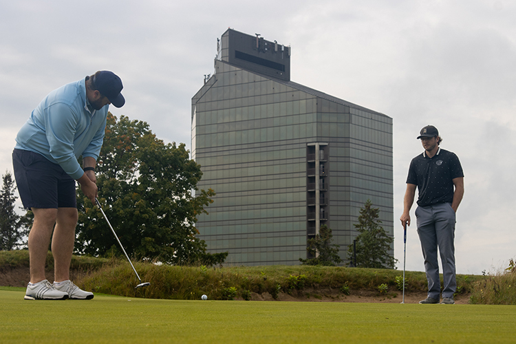 Image of two golfers in front of the Grand Traverse Resort.