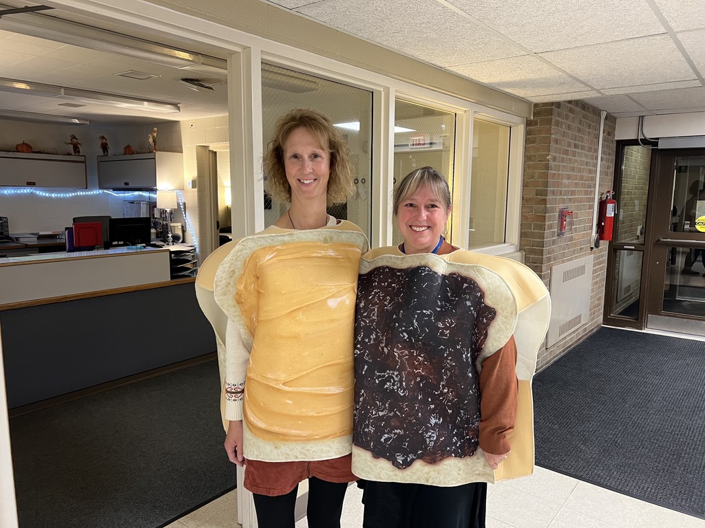 Bridgeway secretary Melissa, who is dressed like peanut butter, posing with principal Becky, who is dressed like jelly.