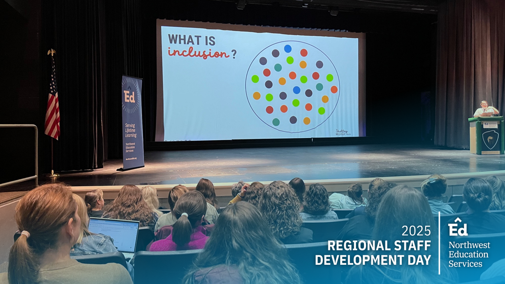 Image of Dr. Shelley Moore presenting on Inclusive Education for All Students for in the Traverse City West Senior High auditorium for Regional Staff Development Day. The projection reads “What is inclusion?”.