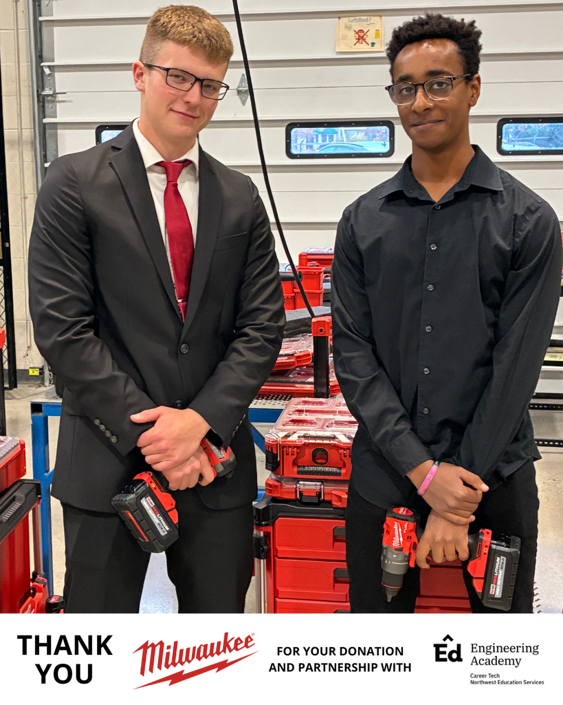 Two students stand side by side in front of a workshop area filled with Milwaukee Packout toolboxes. Both are wearing dress shirts and black pants—one with a red tie and the other with an open-collar black shirt. They are each holding a red Milwaukee cordless drill and smiling slightly. At the bottom of the image, there is a thank-you banner featuring the Milwaukee and Engineering Academy logos, along with the text “THANK YOU FOR YOUR DONATION AND PARTNERSHIP WITH Ed Engineering Academy.”